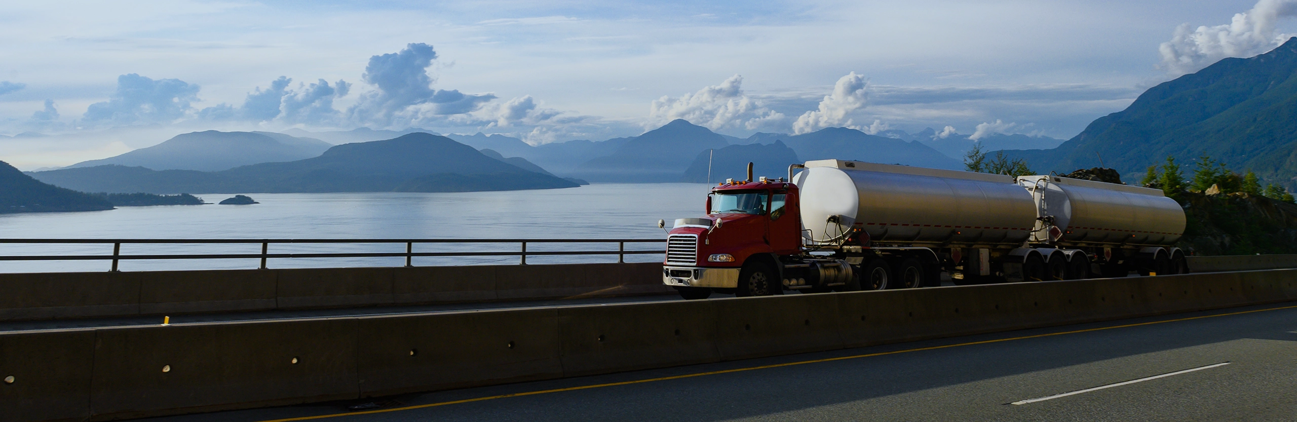 DSN Chemical Transportation carrier partner double tanker truck transporting chemical freight in front of North American lake