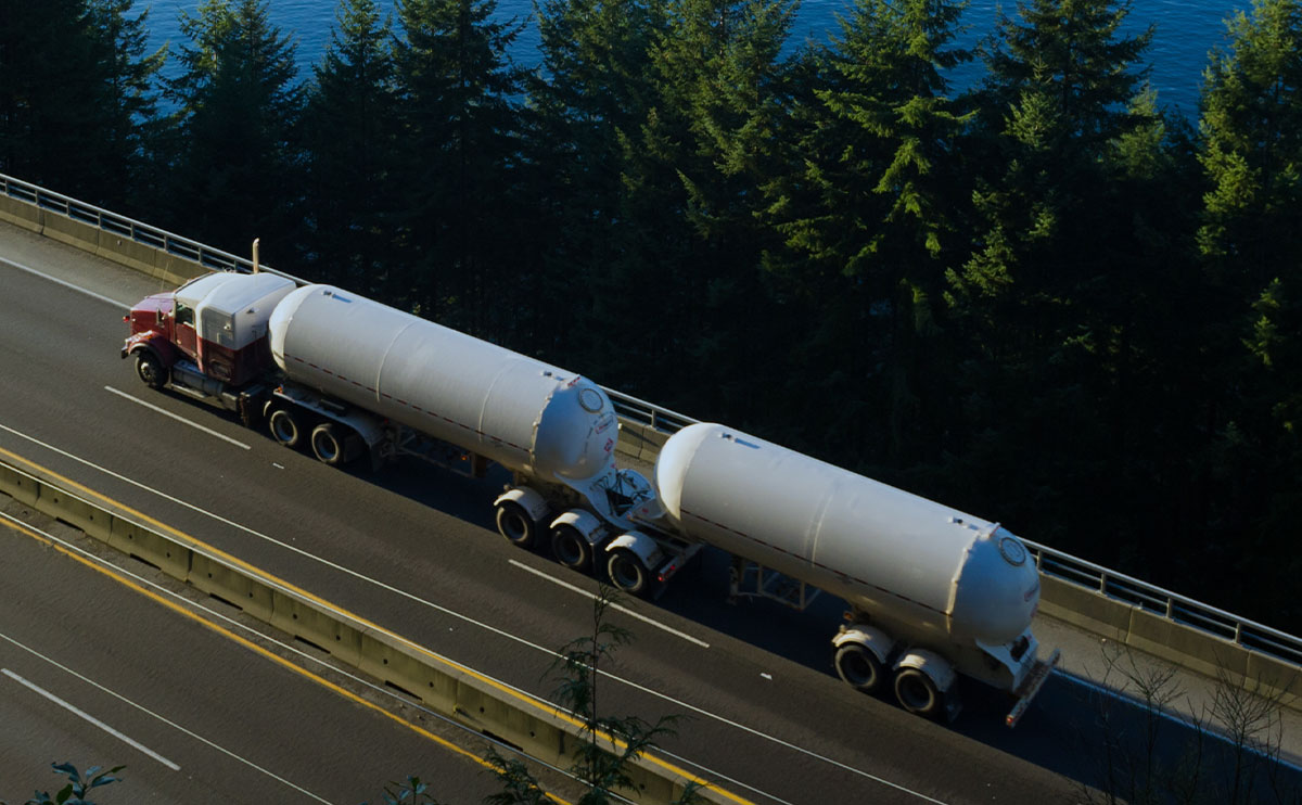 DSN Chemical Transportation carrier partner double tanker truck driving on North American highway alongside lake